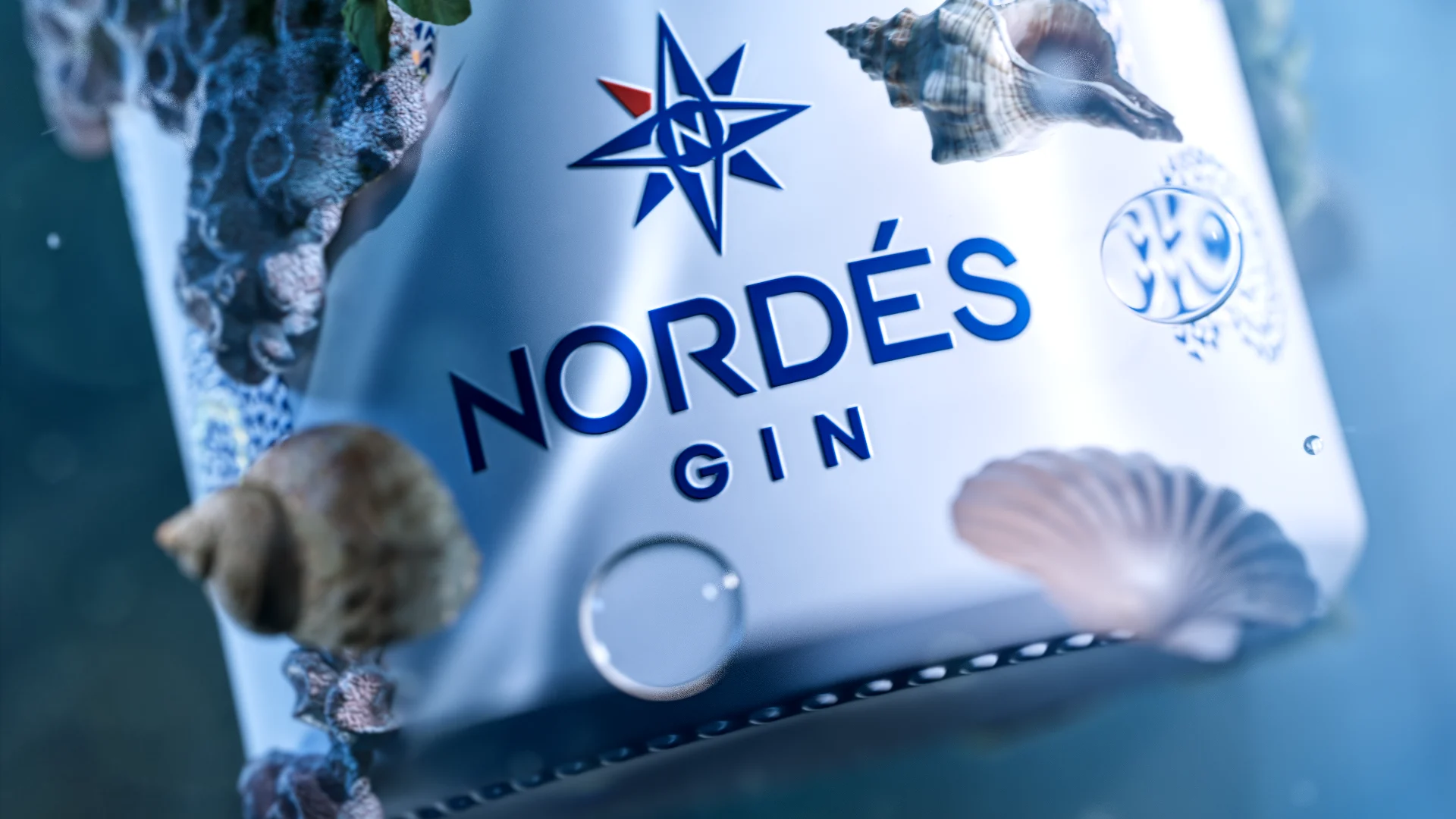 Botella de Nordés Gin en CGI entre conchas y elementos marinos